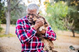 A man hugs his dog as he learns to live a joyful life with chronic illness.